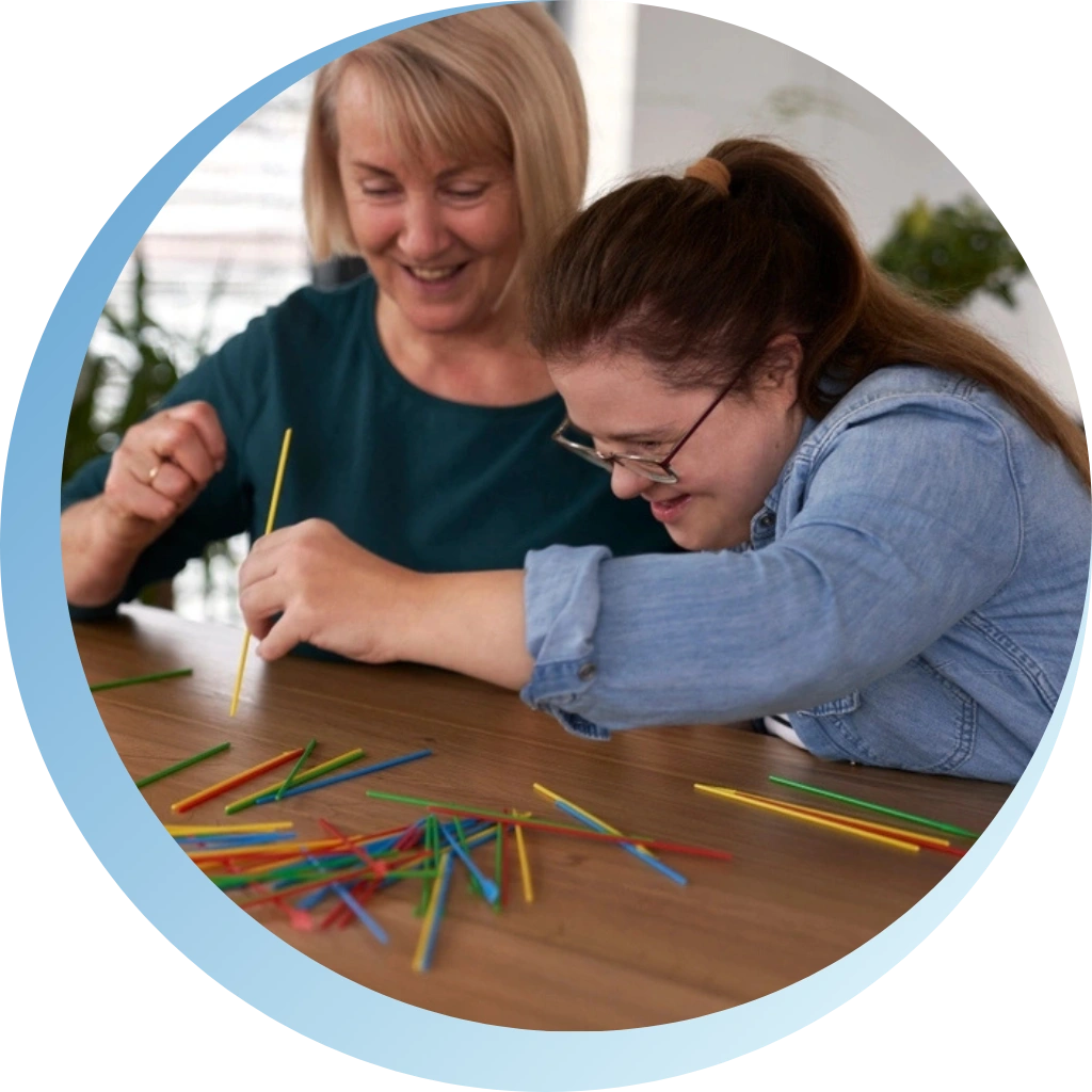 disability support carer assisting disabled girl and playing with her